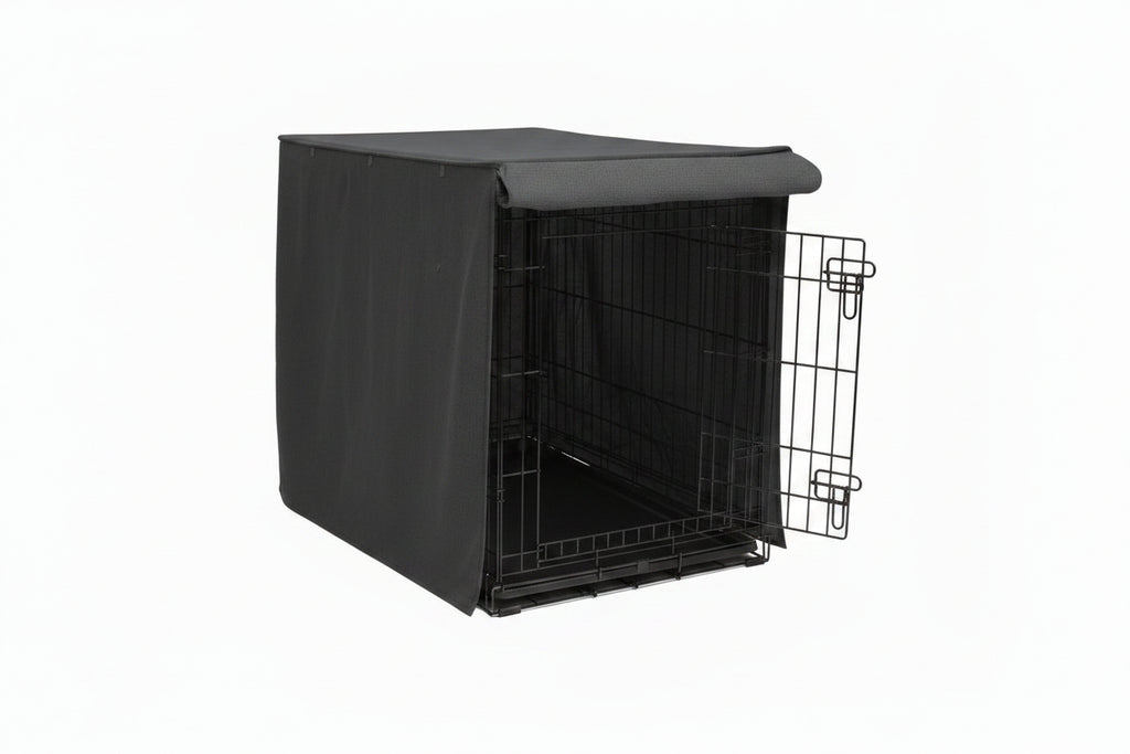 Dog sitting next to a black dog crate with a cover on a white background